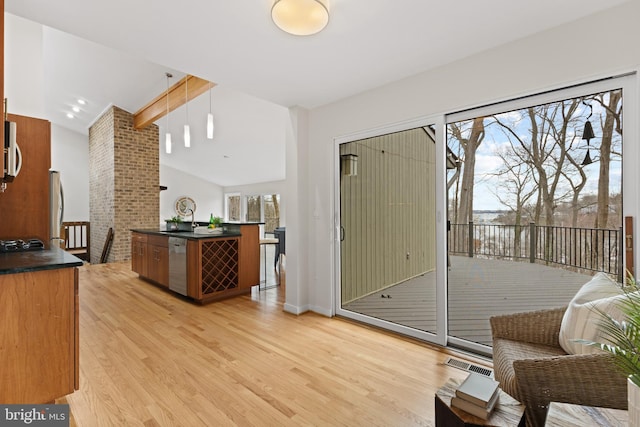 interior space with light wood finished floors, visible vents, vaulted ceiling with beams, and baseboards