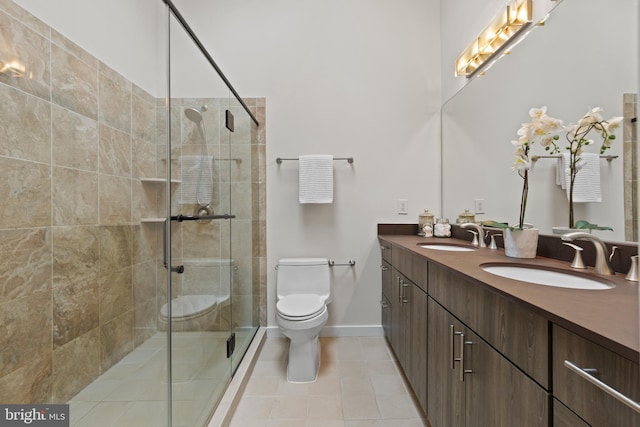 bathroom with a sink, toilet, a stall shower, and double vanity