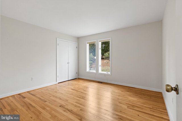 empty room featuring visible vents, baseboards, and light wood-type flooring