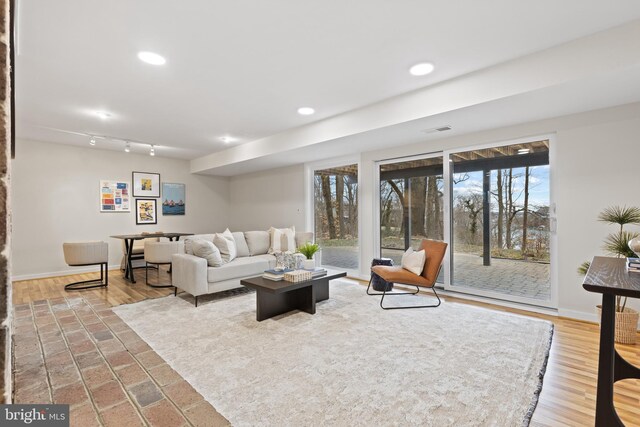 living area with recessed lighting, visible vents, and baseboards