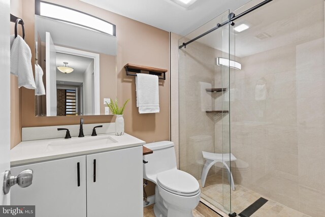 bathroom with a stall shower, toilet, and vanity