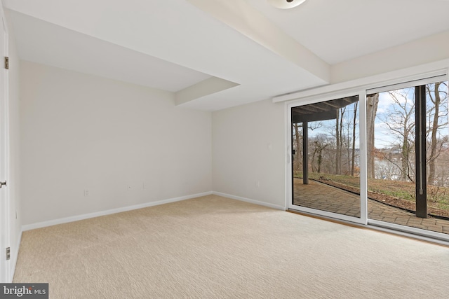 carpeted spare room featuring plenty of natural light and baseboards