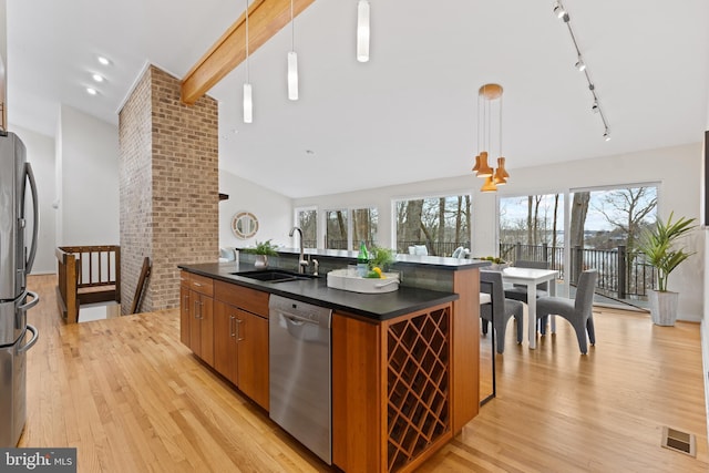 kitchen featuring dark countertops, visible vents, appliances with stainless steel finishes, and a sink