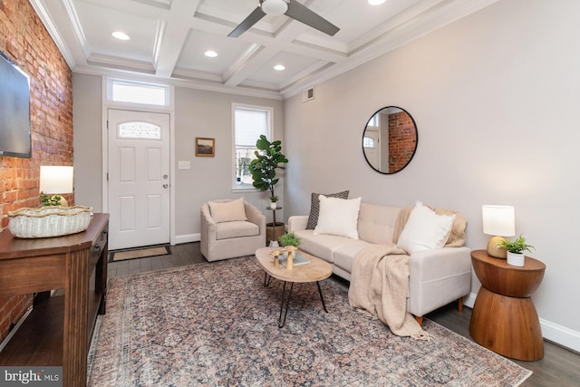 living room featuring coffered ceiling, ornamental molding, dark wood-type flooring, ceiling fan, and beam ceiling