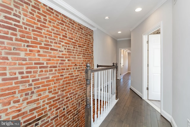 hallway featuring brick wall, crown molding, and dark hardwood / wood-style floors