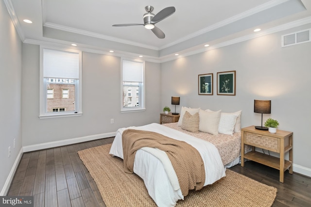 bedroom with crown molding, ceiling fan, a tray ceiling, and dark hardwood / wood-style floors