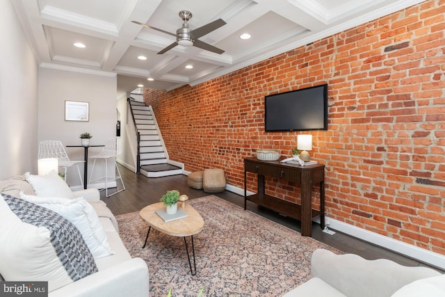 living room featuring dark hardwood / wood-style floors, brick wall, beam ceiling, crown molding, and coffered ceiling