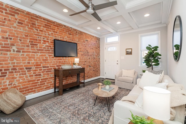 living room featuring dark hardwood / wood-style floors, brick wall, beam ceiling, crown molding, and coffered ceiling