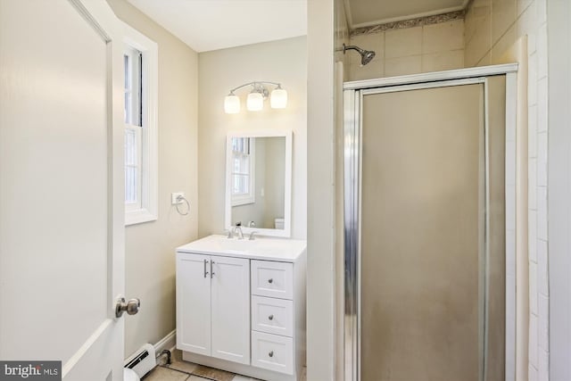 bathroom with tile patterned flooring, vanity, a shower with shower door, and a baseboard heating unit