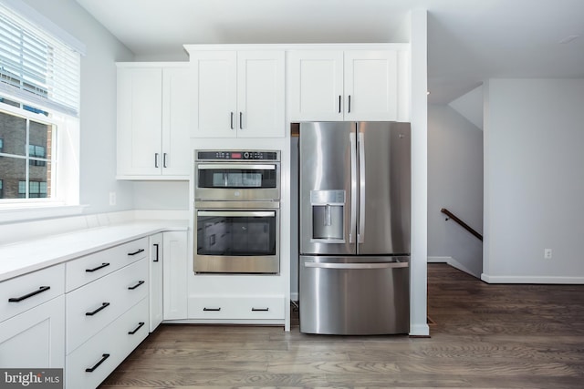 kitchen with white cabinets, dark wood-type flooring, and appliances with stainless steel finishes