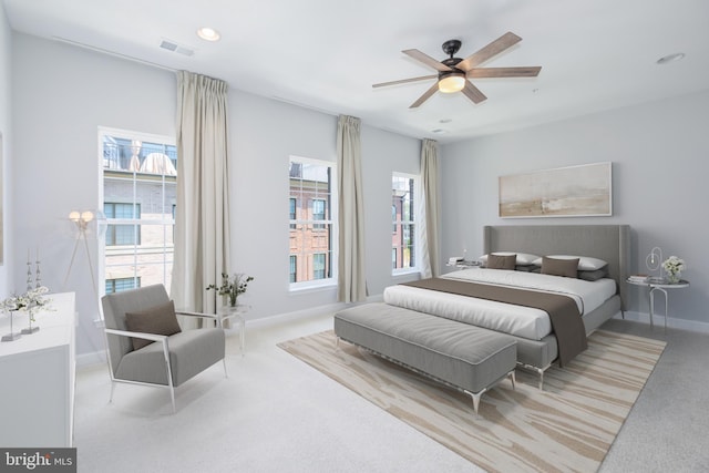 bedroom with ceiling fan and light carpet