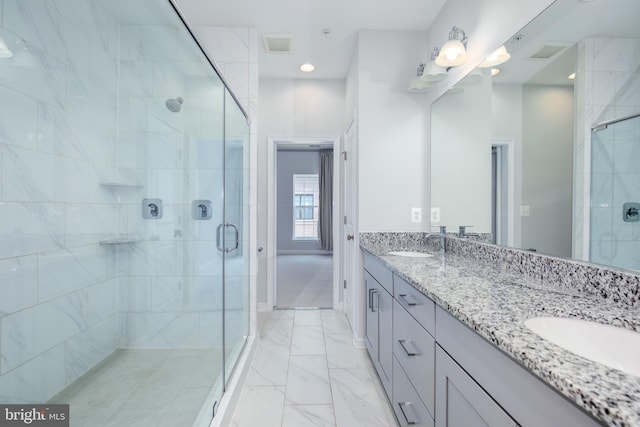 bathroom with a shower with door and vanity