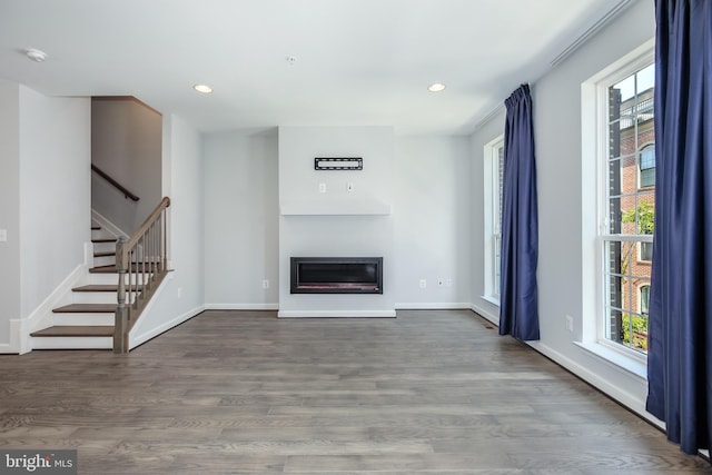 unfurnished living room featuring a healthy amount of sunlight and wood-type flooring