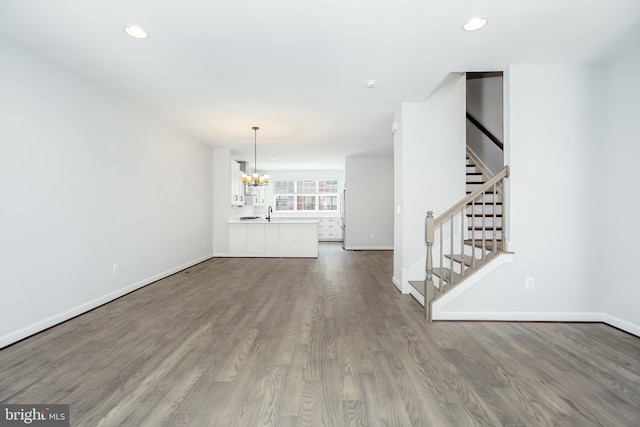 unfurnished living room with hardwood / wood-style flooring and an inviting chandelier