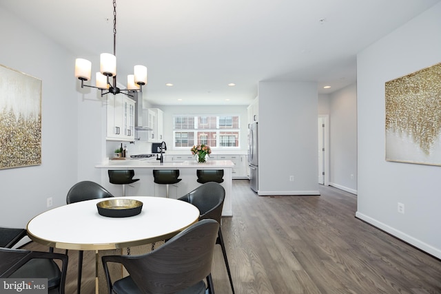 dining room featuring dark hardwood / wood-style flooring, sink, and a chandelier