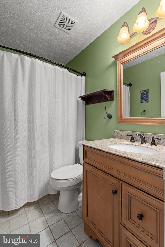 bathroom with toilet, a textured ceiling, tile patterned floors, and vanity