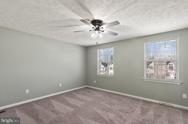 spare room with ceiling fan, carpet, and a textured ceiling