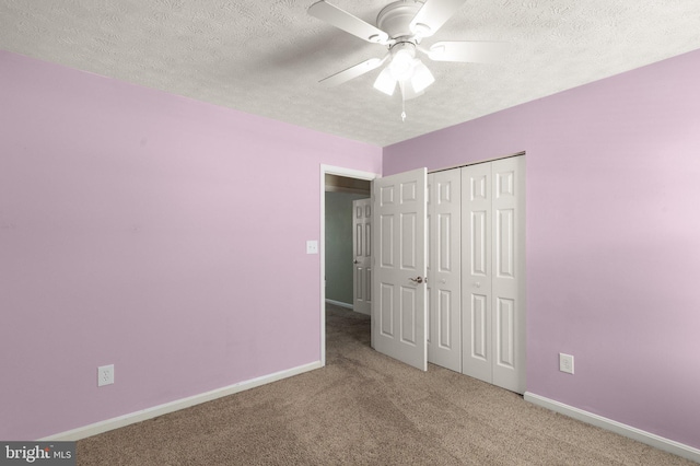 unfurnished bedroom featuring a textured ceiling, carpet floors, ceiling fan, and a closet