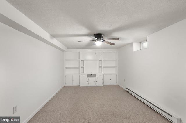 unfurnished bedroom featuring carpet flooring, a textured ceiling, baseboard heating, and ceiling fan