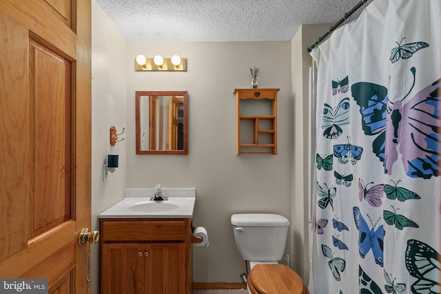 bathroom featuring a textured ceiling, walk in shower, vanity, and toilet