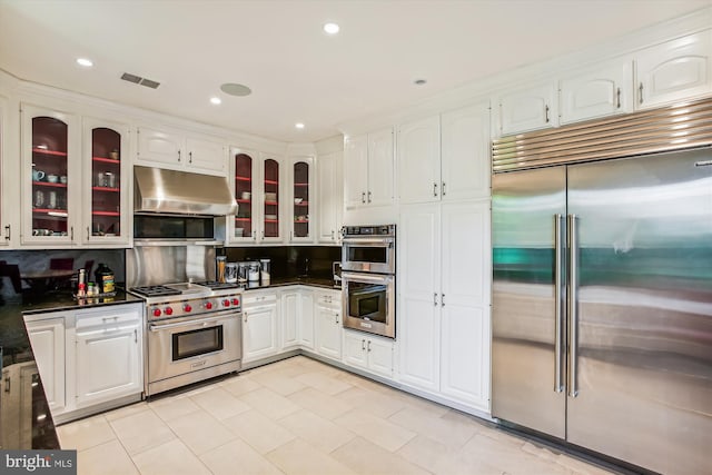 kitchen featuring white cabinets, high quality appliances, and tasteful backsplash