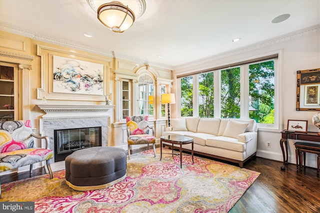 living room with crown molding, a high end fireplace, and dark wood-type flooring