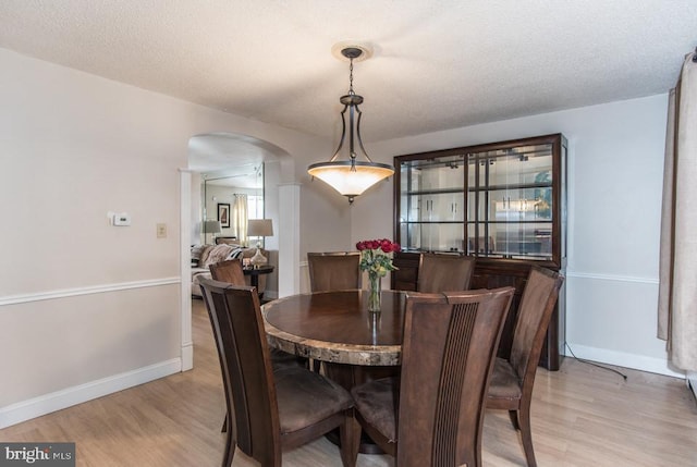 dining room with light hardwood / wood-style floors and a textured ceiling