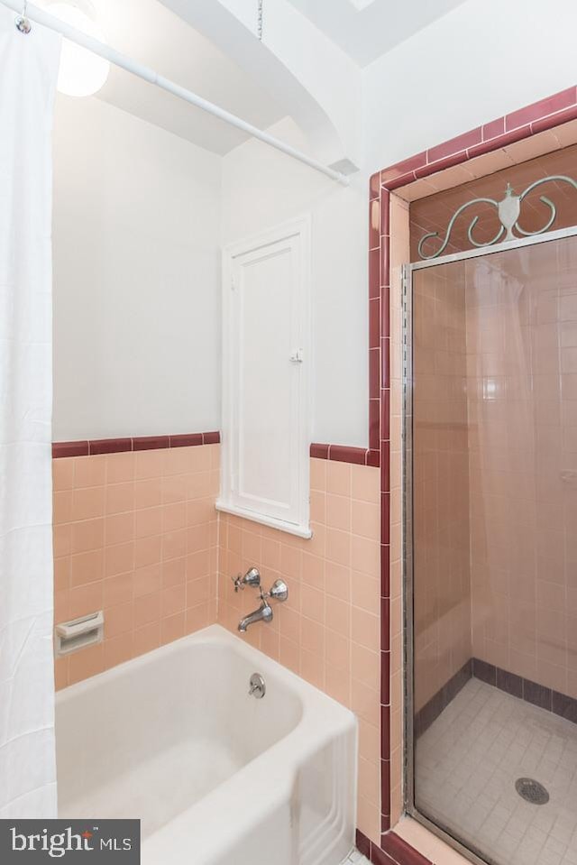 bathroom featuring shower with separate bathtub