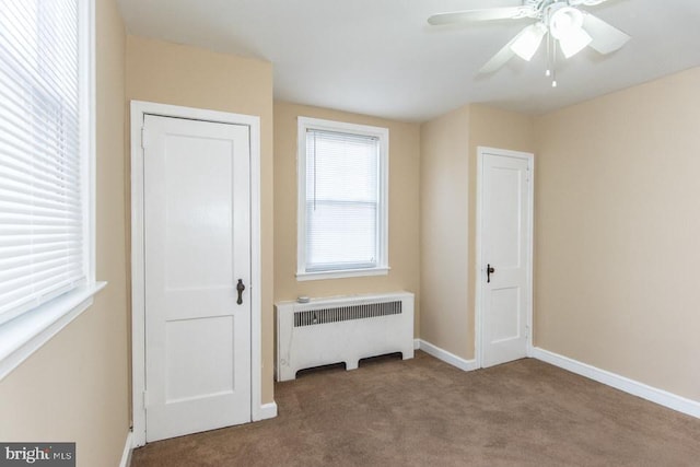 unfurnished bedroom featuring radiator, ceiling fan, and carpet flooring