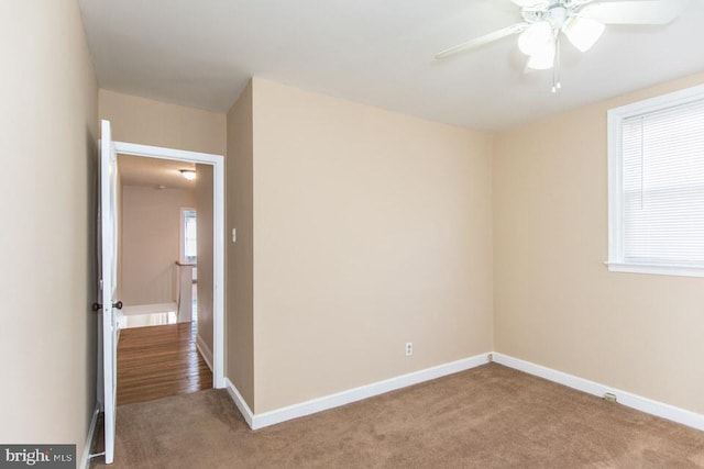 carpeted spare room featuring ceiling fan