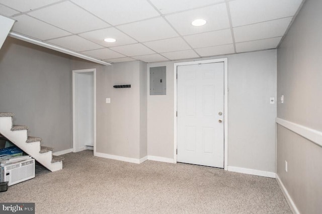 basement featuring carpet floors, electric panel, and a paneled ceiling