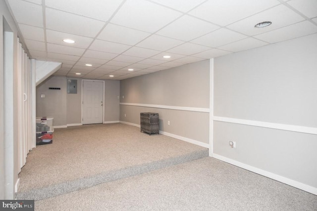 basement featuring a paneled ceiling and carpet