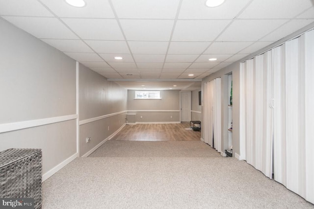 basement with carpet floors and a paneled ceiling