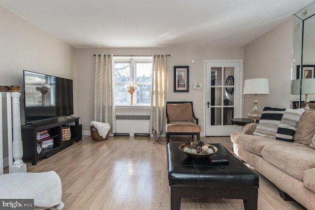 living room with radiator heating unit and light hardwood / wood-style floors