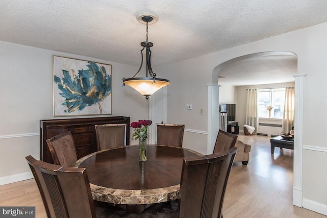 dining space featuring light hardwood / wood-style flooring and a textured ceiling