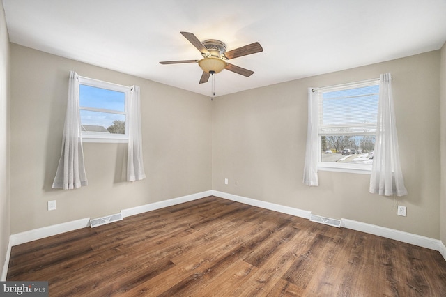 empty room with dark wood-type flooring and ceiling fan