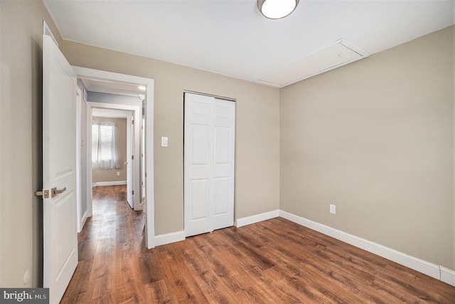 unfurnished bedroom featuring dark hardwood / wood-style flooring and a closet