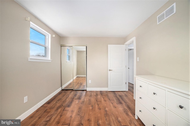 unfurnished bedroom featuring a closet and dark hardwood / wood-style floors