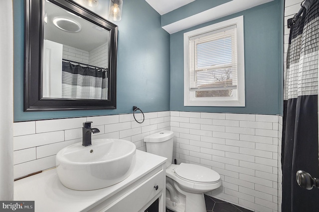 bathroom with tile patterned floors, toilet, a shower with curtain, tile walls, and vanity