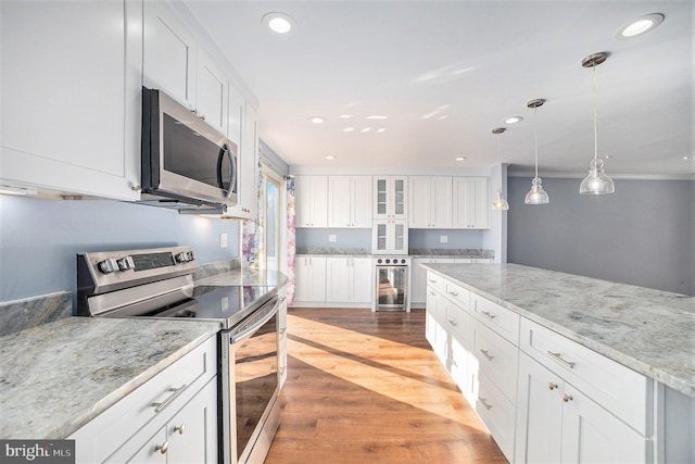 kitchen featuring wine cooler, light stone counters, stainless steel appliances, and white cabinets