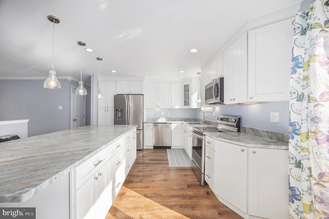 kitchen with sink, white cabinetry, hanging light fixtures, appliances with stainless steel finishes, and dark hardwood / wood-style flooring