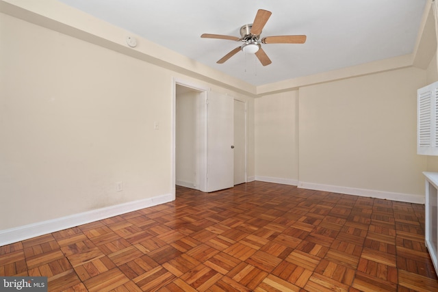 empty room featuring dark parquet flooring and ceiling fan