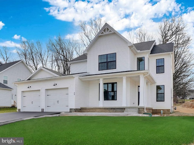 modern inspired farmhouse with a front yard, a porch, and a garage