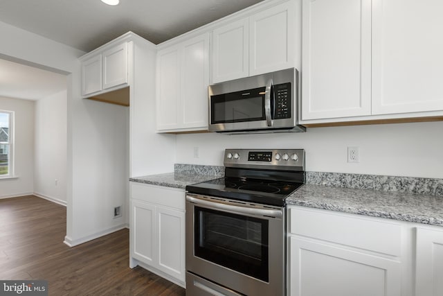 kitchen with white cabinets, dark hardwood / wood-style flooring, light stone countertops, and stainless steel appliances