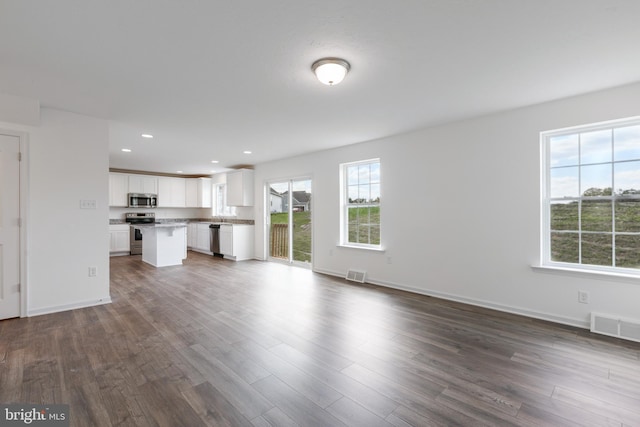 unfurnished living room with dark hardwood / wood-style floors