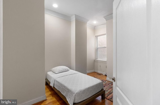 bedroom with crown molding and light wood-type flooring