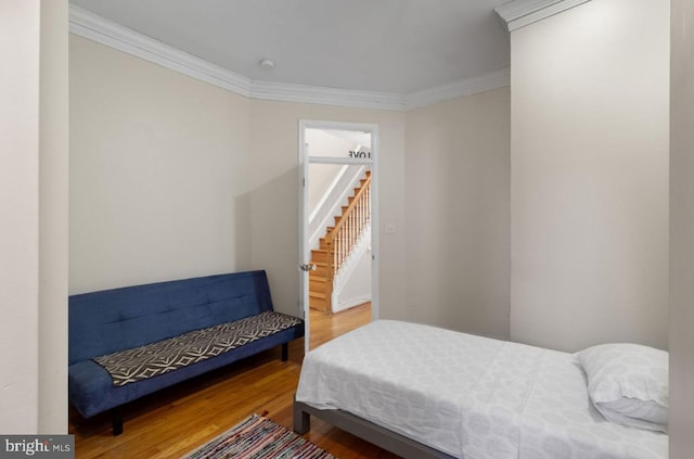 bedroom with crown molding and wood-type flooring