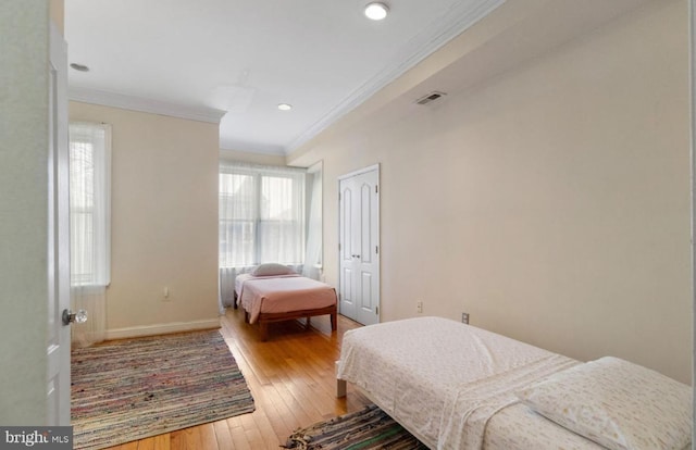 bedroom featuring ornamental molding and hardwood / wood-style flooring