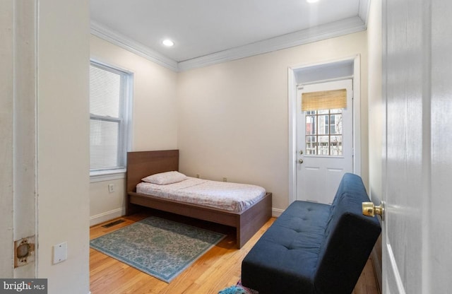 bedroom with crown molding and hardwood / wood-style floors