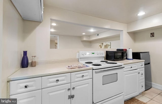 kitchen with light tile patterned floors, white cabinetry, white electric stove, and stainless steel refrigerator